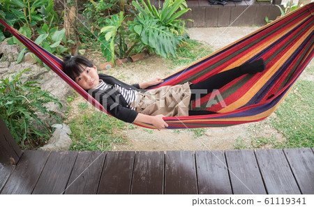 Girl swinging on a hammock Girl swinging on a hammock 61119341