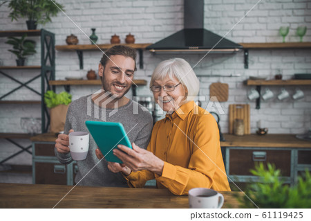 Young handsome man in grey shirt and his mom looking contented 61119425