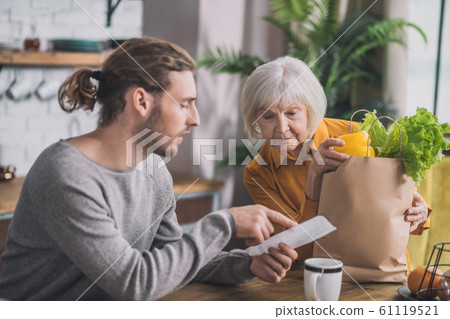 Grey-haired mom and her son talking in the kitchen Grey-haired mom and her son talking in the kitchen 61119521