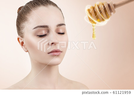 Young woman with closed eye and honey spoon prepare for facial mask. 61121959