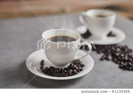 Hot coffee cup and coffee beans. . Hot coffee cup and coffee beans. . 61130369