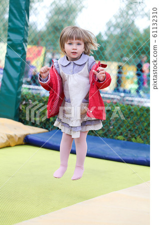 Little girl on playground in a park, jumping  61132310