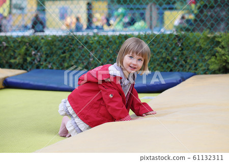 Little girl on playground in a park, jumping  61132311