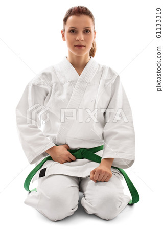 Calm young girl in a kimono kneeling down Calm young girl in a kimono kneeling down 61133319