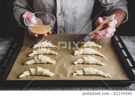 Baking sheet of raw croissants stuffed with 61134560