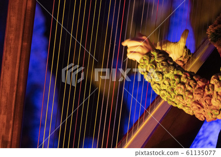 hands playing harp detail 61135077