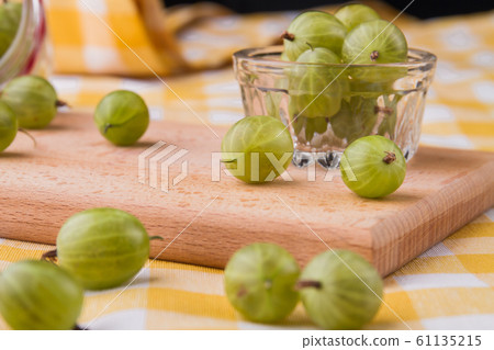 Green cherry-plums on a wooden board. Green cherry-plums on a wooden board. 61135215