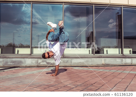 Male dancer dancing in summer city, break dance, fashionable and modern hip-hop dance style. Street lifestyle. Free space for copy text. Male dancer dancing in summer city, break dance, fashionable and modern hip-hop dance style. Street lifestyle. Free space for copy text. 61136120