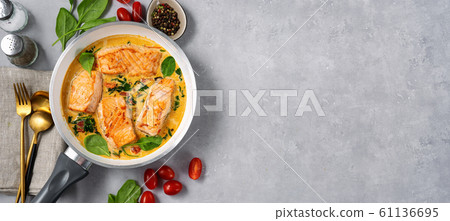 Salmon steaks in a frying pan with cream on light Salmon steaks in a frying pan with cream on light 61136695