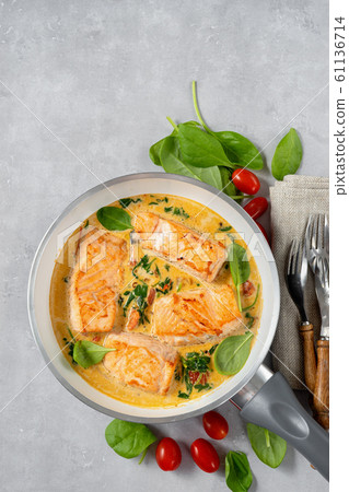 Close up of salmon peaces in a frying pan Close up of salmon peaces in a frying pan 61136714
