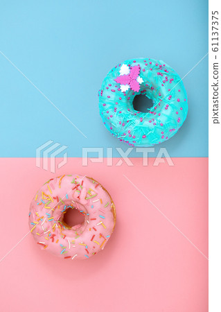 Two donuts on pastel pink and blue background. Minimalism creative food composition. Flat lay style Two donuts on pastel pink and blue background. Minimalism creative food composition. Flat lay style 61137375