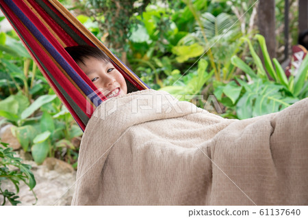 Boy swinging in a hammock Boy swinging in a hammock 61137640