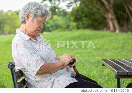 Asian senior woman sit asleep,snooze on chair,elderly female closed her eyes,resting in summer green nature,old people feeling falling asleep,doze,sleepy in outdoor park,lack of sleep concept 61141946