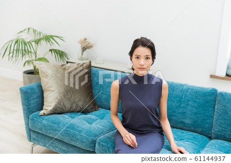 一位年輕的女士坐在沙發上 61144937