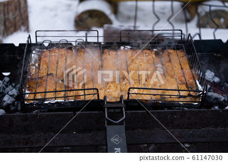 Barbecue meat on the grill on the fire in the open air. Russia. Winter. Barbecue meat on the grill on the fire in the open air. Russia. Winter. 61147030