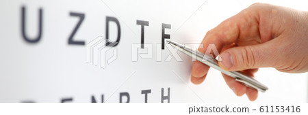 Silver ballpoint pen pointing to letter in eyesight check table 61153416