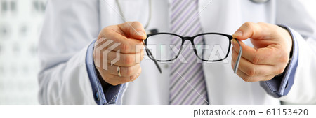 Male medicine doctor hands giving pair of black glasses 61153420