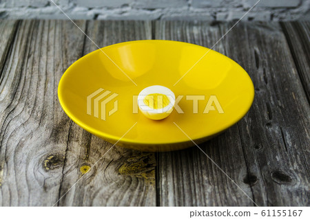 one boiled egg half in a bowl on a table, concept of loneliness one boiled egg half in a bowl on a table, concept of loneliness 61155167
