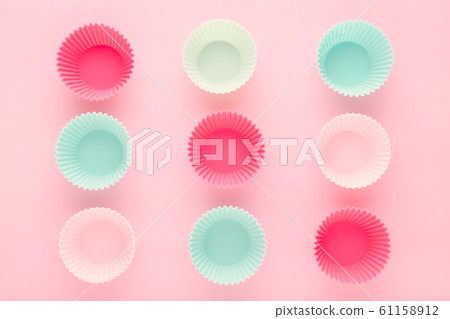 silikone forms for baking muffins and cupcakes on pastel pink background 61158912