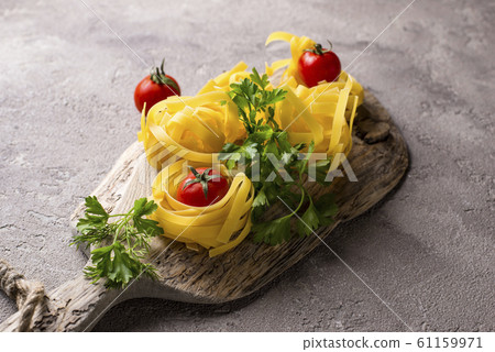 Raw pasta tagliatelle or fettuccine Raw pasta tagliatelle or fettuccine 61159971