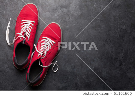 Pair of red sneakers over stone Pair of red sneakers over stone 61161600
