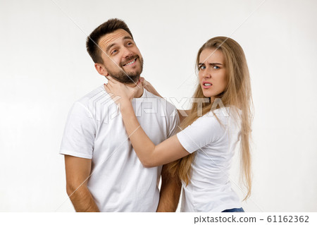 woman jokingly strangles man. woman jokingly strangles man. 61162362