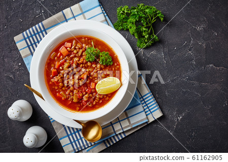 lentil soup with vegetables and a lemon wedge 61162905