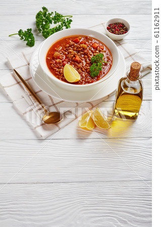 lentil soup with vegetables and lemon wedge 61162911