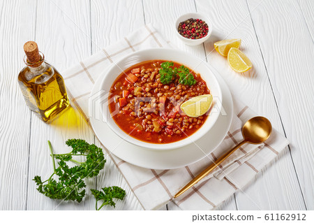 lentil soup with vegetables and lemon wedges 61162912