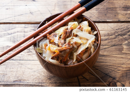 Stewed cabbage with meat in a wooden bowl on a 61163145