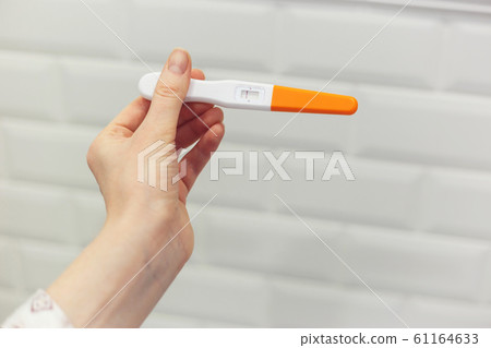 Rapid pregnancy test with negative result in woman's hand. Human chorionic gonadotropin test 61164633