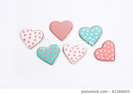Gingerbread cookies with frosting in the shape of a heart on white background. 61166003