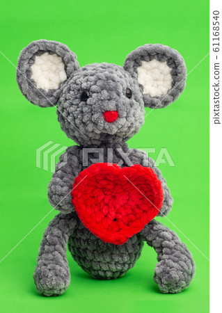 Grey knitted mouse with a heart in hand on a green Grey knitted mouse with a heart in hand on a green 61168540