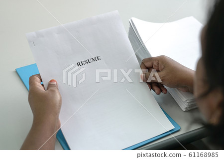 Hiring Manager holding a copy of resume 61168985