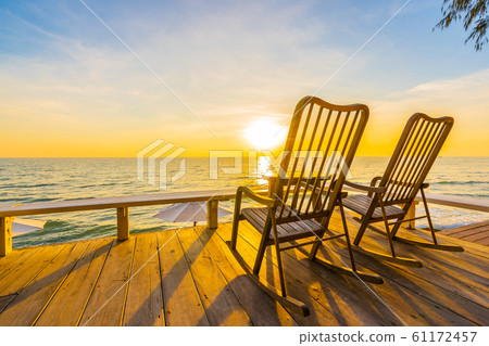 Empty wood chair and table at outdoor patio with beautiful tropical beach and sea 61172457