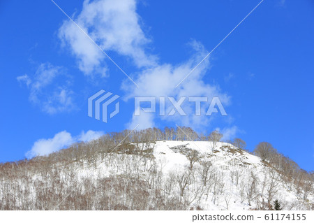 A view of the clear winter sky (blue sky + clouds + mound + birch forest) 61174155