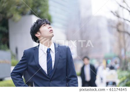 A businessman looking up at the sky 61174845
