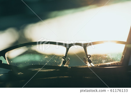 Close-up glasses with camera flare at sunrise Close-up glasses with camera flare at sunrise 61176133