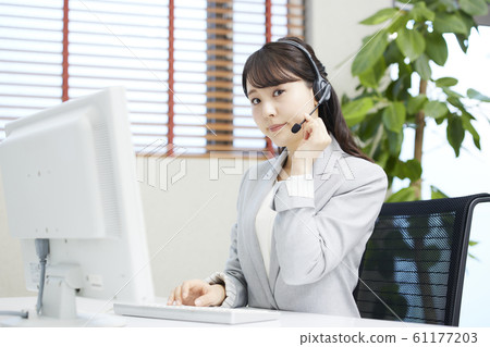 在呼叫中心接線員工作的年輕女子 61177203