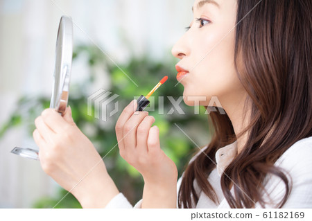A woman applying lip gloss 61182169