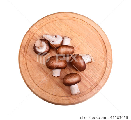 Raw mushrooms on the cutting board over white Raw mushrooms on the cutting board over white 61185456