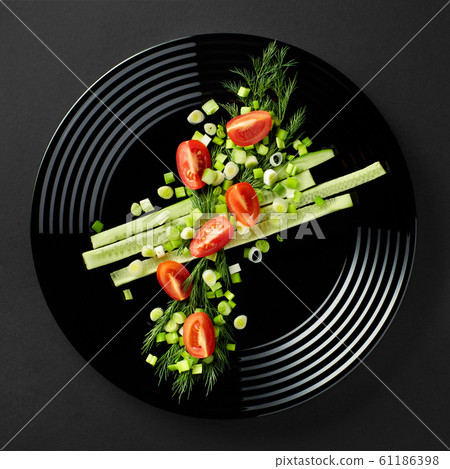 simple vegetable salad on a black plate. close-up on a dark background. Instagram simple vegetable salad on a black plate. close-up on a dark background. Instagram 61186398