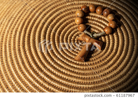 Tau - Wooden Cross and Rosary Bead on woven wicker texture Tau - Wooden Cross and Rosary Bead on woven wicker texture 61187967