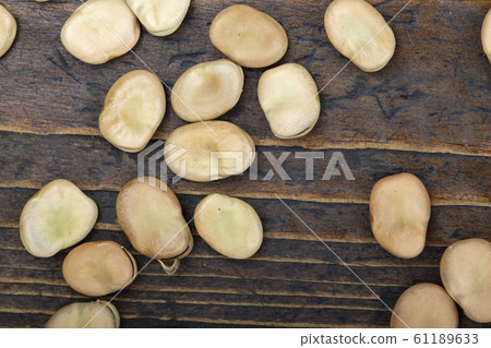 dry broad beans on a wooden background 61189633