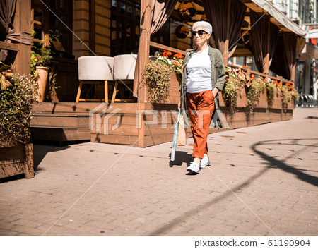 Smiling senior woman walking on the street Smiling senior woman walking on the street 61190904