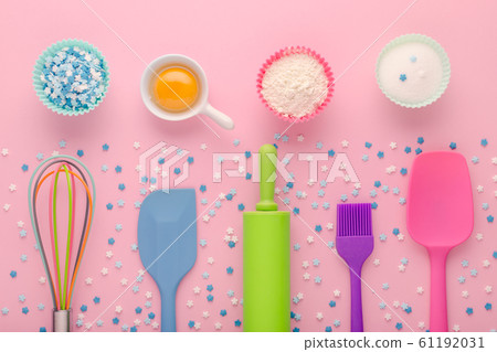 baking ingredients, egg, flour, sugar, sweet decoration and kitchen tools on pink background baking ingredients, egg, flour, sugar, sweet decoration and kitchen tools on pink background 61192031