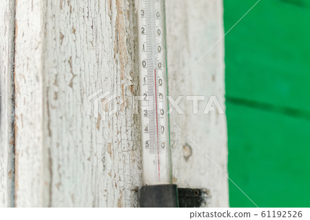 Old outdoor thermometer on a wooden house 61192526