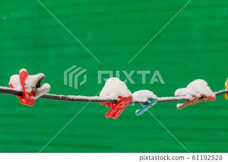 Clothespins on clothesline covered with snow Clothespins on clothesline covered with snow 61192528