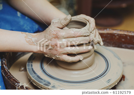 Woman hands on pottery wheel. Craftsman artist Woman hands on pottery wheel. Craftsman artist 61192579