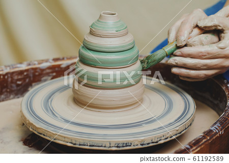 Hands on pottery wheel. Craftsman artist painting 61192589